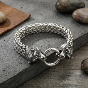 Detail of vintage braided steel bracelet featuring dual animal heads and spring clasp