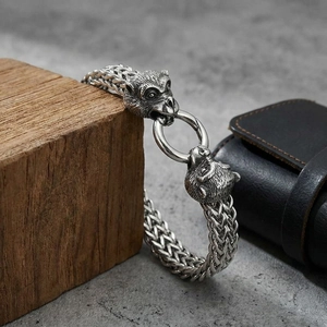 Macro detail of double ape head charms on steel woven bracelet for men
