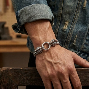 Detailed shot of men's vintage steel bracelet with twin rooster heads and braided chain