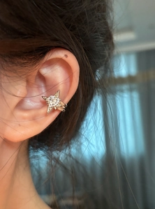 Close-up of a sparkling star zircon ear cuff worn on the ear bone, non-pierced design.