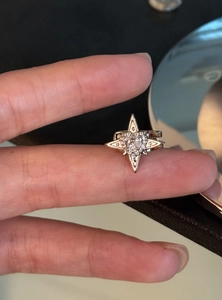 Close-up of star-shaped ear cuff with zircon inlay on hand