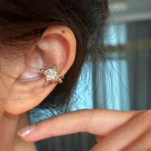 Macro detail of a luxurious sparkling zircon star ear cuff for women no piercing
