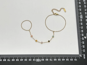 Detail of 18K gold-plated slave bracelet with five colored zircons and measuring tool
