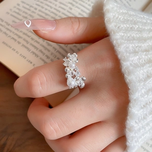 Close-up detail of a minimalist floral silver open ring with pearls and zircons