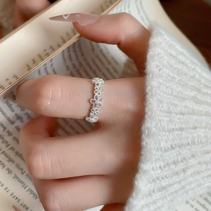 Detailed macro view of a sparkling zircon flower open ring with elegant silver finish.