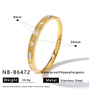 Detail of gold stainless steel bangle with zirconia, 8mm width and 50mm diameter
