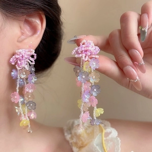 Close-up of multi-colored floral tassel earrings with pink beaded details