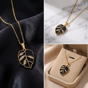 Detail views of gold stainless steel leaf pendant necklace with black enamel and crystals.