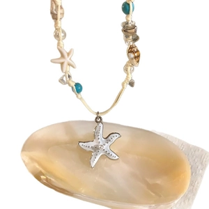 Handmade woven necklace with starfish charms, natural shells, and turquoise beads.