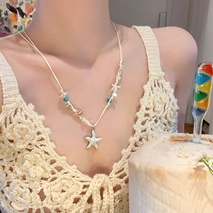 Close-up of a handmade beaded starfish and shell necklace in beach vacation style