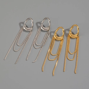 Detailed macro view of gold and silver liquid metal tassel earrings on gray background