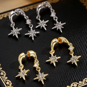 Detailopname van elegante gouden en zilveren sterren oorbellen met micro-pave zirkonia details