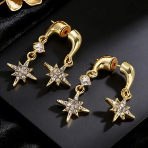 Macro-opname van elegante gouden ster-oorbellen met fonkelende ingelegde microkristallen.