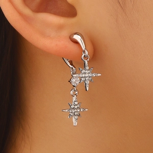 Detailopname van elegante zilveren ster oorbellen met micro-pave kristallen aan het oor getoond