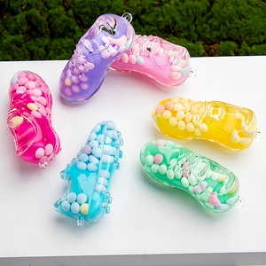 Close-up of colorful sneaker keychains filled with vibrant moving sand and beads