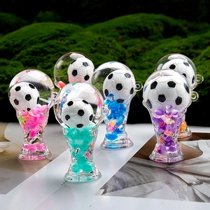 Close-up of acrylic football trophy keychains with colorful beads on mossy green background