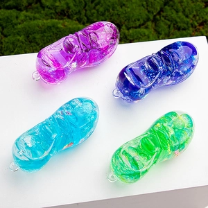Macro detail of acrylic soccer shoe pendants with colorful glitter in blue, purple and green