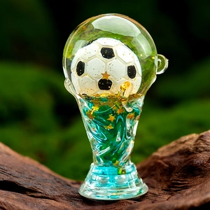 Macro detail of acrylic football trophy keychain with blue spiral resin and gold stars