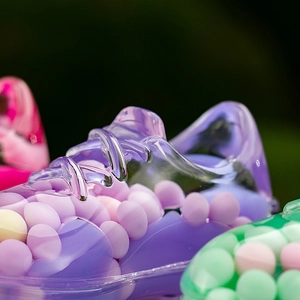 Macro shot of creative sneaker-shaped acrylic liquid bottle with colorful beads inside
