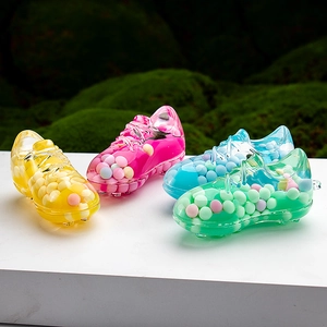 Macro view of colorful acrylic sneaker-shaped containers with vibrant liquid sand beads
