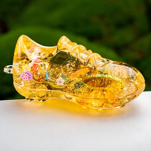 Close-up of yellow soccer shoe liquid acrylic keychain with gold glitter and sequins