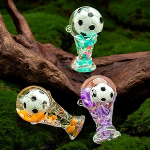 Macro detail of acrylic world trophy keychains with floating football and colorful sand