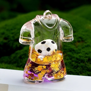Vue macro d'un porte-clés maillot de foot en acrylique avec liquide doré et mini ballon