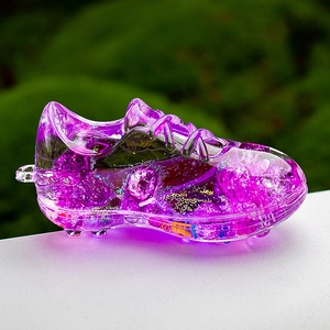 Close-up of purple acrylic soccer shoe keychain filled with glitter and crushed stones
