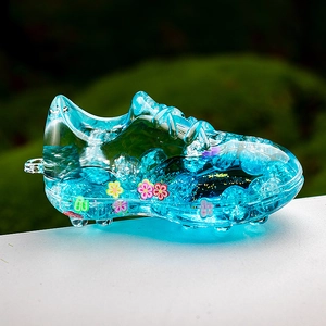 Detail of blue liquid-filled football shoe keychain with sparkling colorful sequins