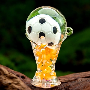 Macro detail of acrylic world trophy keychain with liquid sand and a mini football inside