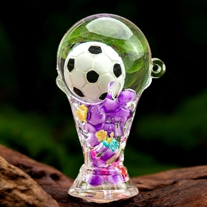 Macro detail of a glass pipe featuring a miniature soccer ball and purple floral stem