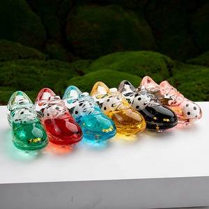 Macro shot of colorful soccer shoe shaped acrylic charms with liquid sand and stars