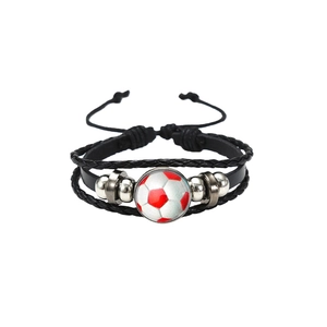 Macro view of a soccer-themed multi-layer black leather bracelet with red ball pattern
