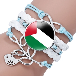 Close-up of multilayer Palestine flag infinity bracelet with bird charm on wrist