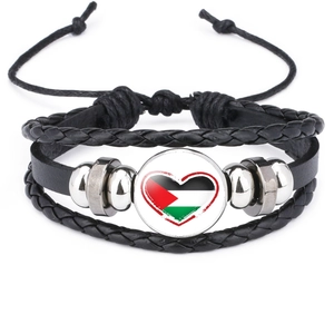 Close-up of black braided leather bracelet with Palestine flag heart glass gem detail