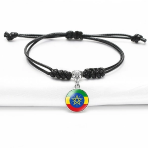 Adjustable black woven bracelet with silver charm featuring the Ethiopia flag design