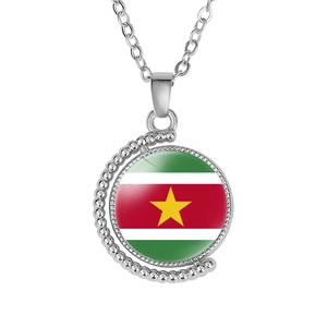 Detailed view of spinning alloy moon pendant with Suriname flag pattern on glass cabochon