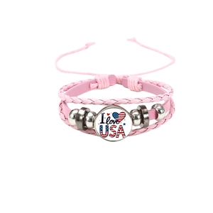 Détail d'un bracelet en cuir rose multicouche avec breloque cœur USA et perles argentées