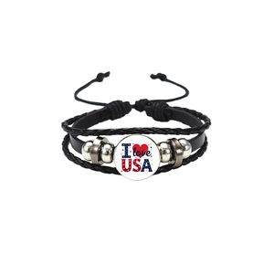 Détail d'un bracelet en cuir tressé avec breloque I Love USA et perles argentées