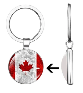 Detail of metal keychain with Canada flag maple leaf under a glass cabochon pendant