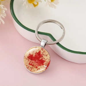 Close-up of Canada maple leaf keychain on white heart tray with pink background