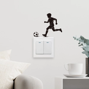 Detail showing a black soccer boy wall sticker applied above a light switch plate