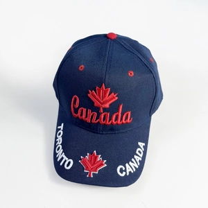 Macro detail of 3D Canada embroidery and maple leaf on navy blue cotton baseball cap