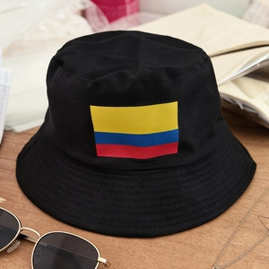 Foldable black bucket hat with Colombia flag emblem on a wooden surface with sunglasses