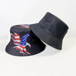 Détail d'un chapeau bob avec imprimé aigle drapeau USA à côté d'un chapeau de soleil noir pur