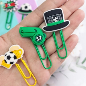 Macro shot of colorful soccer-themed paper clips with PVC whistle and ball shapes