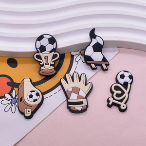 Five-piece set of football themed PVC shoe charms for clogs featuring trophy and ball