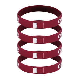 Set of four Qatar flag sports silicone wristbands with QAR letters on white background