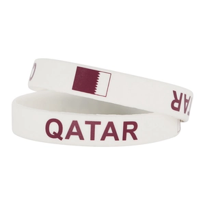 Close-up of dual white silicone Qatar national flag wristbands for sports fans