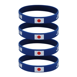 Set of four blue silicone Japan sports wristbands with flag and text on white background